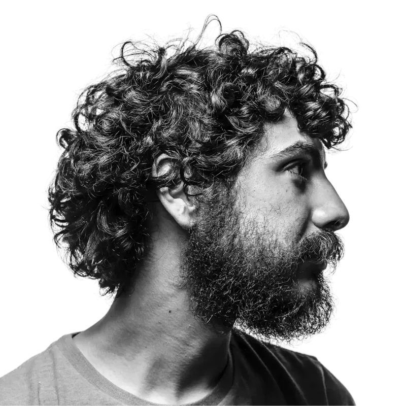 Black and white portrait of a bearded man with curly hair looking to the side