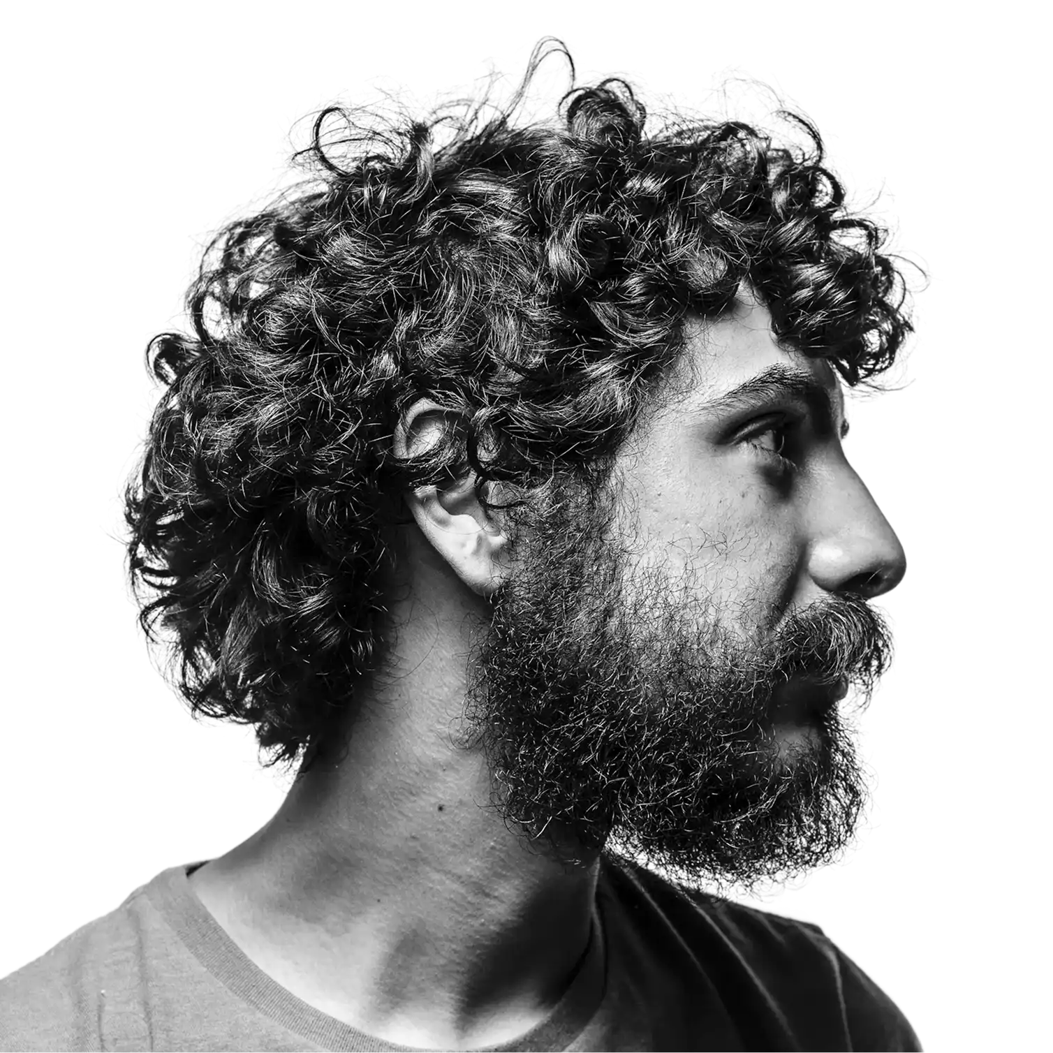 Black and white portrait of a bearded man with curly hair looking to the side